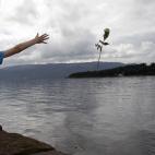 Un niño lanza una flor al mar, en la isla de Utoya, en recuerdo de las víctimas de la matanza de Breivik