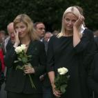 Las princesas Mette-Marit y Marta Luisa de Noruega se secan las lágrimas mientras escuchan, junto a miles de personas, un discurso durante la vigilia en memoria de las víctimas, en Oslo, tres días después de la tragedia.