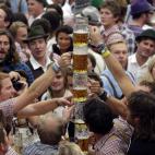 Asistentes al festival brindan con sus jarras de cerveza
