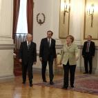 El primer ministro griego, Samaras, escolta a Merkel en el palacio presidencia de Atenas para reunirse con Papoulias.