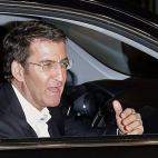 Alberto Núñez Feijóo saluda a la prensa desde el coche en el que llega a la sede del partido, en Santiago de Compostela, para seguir el recuento de los resultados.