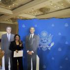 Una votante en la embajada en San Salvador se toma una foto con un par de reproducciones de cartón de Obama y Romney