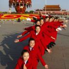 Un grupo de azafatas posan para el fotógrafo frente al Gran Palacio del Pueblo, antes de la celebración de la ceremonia de apertura del Congreso del Partido Comunista de China