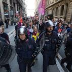 Riot policemen march in front of demonstrators during a protest on a day of mobilisation against austerity measures by workers in southern Europe on November 14, 2012 in Rome. Thousands of people took to the streets of major cities including Mil...