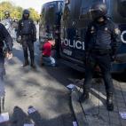 A man kneels down handcuffed next to police vans after being detained by the police during a general strike in Madrid, Wednesday Nov. 14, 2012. A Spanish Interior Ministry official says 32 people have been arrested and 15 people treated for mino...