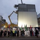Construction work continues as protesters take part in a picket and demonstration they said was over dismissals of 28 workers employed by contractors on the Crossrail transport project, for being trade union members, in London, Wednesday, Nov. 1...
