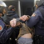 Police riots arrest a protestor during a general strike in Madrid, Spain, Wednesday, Nov. 14, 2012. Spain's main trade unions stage a general strike, coinciding with similar work stoppages in Portugal and Greece, to protest government-imposed au...