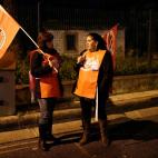 Two workers' union members man a piquet at the gate of a garbage processing plant in Lisbon Wednesday night, Nov. 13 2012, at the start of a general strike in Portugal. Workers' unions called a general strike for Nov. 14 to protest the governmen...