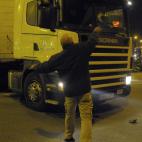 A protester throws a stone to a truck at the main entrance to Mercabarna, the biggest wholesale market, during a general strike in Barcelona, Spain, Wednesday, Nov. 14, 2012. Spain's main trade unions will stage a general strike, coinciding with...
