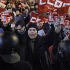 A protester shouts slogans in front of an open shop as police stand guard during a general strike in Madrid, Spain, Wednesday, Nov. 14, 2012. Spain's main trade unions stage a general strike, coinciding with similar work stoppages in Portugal an...