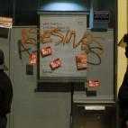 Policemen guard a Bankia bank with a graffiti reading ''Assassins" during a general strike in Madrid, Spain, Wednesday, Nov. 14, 2012. Spain's main trade unions stage a general strike, coinciding with similar work stoppages in Portugal and Greec...