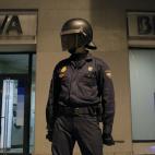 A riot policeman stands guard in front of a bank during a general strike in Madrid, Spain, Wednesday, Nov. 14, 2012. Spain's main trade unions stage a general strike, coinciding with similar work stoppages in Portugal and Greece, to protest gove...