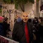 An anti-austerity protester wearing a pig mask takes part in what they called 'the Plebs & PIIGS Banquet', a demonstration outside the Lord Mayor's Banquet in the City of London, Monday, Nov. 12, 2012. PIIGS is a reference to people from Portuga...