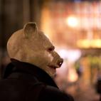 An anti-austerity protester wearing a pig mask takes part in what they called 'the Plebs & PIIGS Banquet', a demonstration outside the Lord Mayor's Banquet in the City of London, Monday, Nov. 12, 2012. PIIGS is a reference to people from Portuga...