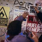 People stick trade union poster calling for a general strike, on upcoming Wednesday Nov. 14, against government austerity measures, right, beside another poster reading: ''Youth unstable'', in Pamplona, northern Spain, Monday, Nov. 12, 2012. (AP...