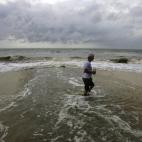 Un hombre camina por la orilla del mar en la playa de Gulfport, Misisipi, Estados Unidos, este martes 28 de agosto de 2012, a pesar de la alerta máxima que se mantiene en las zonas costeras ante la llegada de la tormenta tropical Isaac.