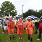 Un grupo de manifestantes se protege de la lluvia durante la Convención Nacional Republicana el 27 de agosto de 2012 cerca del centro de Tampa, Florida. Las cancelaciones en las líneas de autobús debido a la tormenta tropical Isaac han imped...