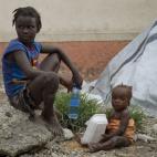 Niños sentados en el suelo esperando a recibir ayuda tras el paso de la tormenta por Puerto Príncipe (Haití), el pasado 26 de agosto.