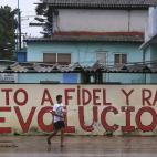 Un hombre camina al lado de un mural después de la tormenta en la Habana este domingo.