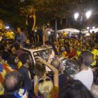 Varios manifestantes se suben en los coches de la Guardia Civil mientras los agentes registran la Conseller&iacute;a de Econom&iacute;a en Barcelona.&nbsp;


