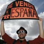 Un manifestante porta una pancarta que reza: "Se vende España"