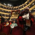 El conocido como 'Mocito Feliz' (d), junto a otras personas disfrazadas, espera en el interior del Teatro Real