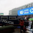 Vehículos policiales que forman parte del dispositivo de seguridad son estacionados en una de las entradas a la Cumbre del Clima que arranca este lunes en Madrid.