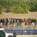 Un buen número de inmigrantes escala la valla fronteriza con el objetivo de alcanzar territorio español (12 de agosto).