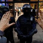 Un manifestante, con sus manos levantadas, frente a un agente