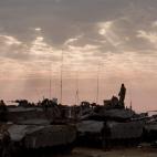 Soldados israelíes permanecen sobre sus tanques al amanecer en la frontera con la Franja de Gaza 