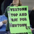 Una aficionada de los New York Jets muestra una pancarta en apoyo a las víctimas de Newtown.