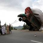 3 abril 2012 Un grupo de hombres utiliza en Pakistán cadenas para tratar de reducir una sobrecarga de los camiones de grano, que se utiliza para la alimentación animal.