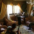 14 agosto 2012 Un combatiente del ejército de liberación sirio apunta con su fusil hacia la calle desde el salón de una casa en Alepo.
