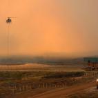 Un helicóptero antiincendios recarga agua para acudir a apagar un fuego en un incendio en Merna, Nebraska (EE UU).