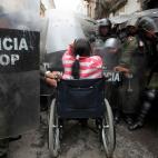 23 febrero 2012 Una mujer en silla de ruedas se introduce entre la formación policial durante unas protestas en La Paz, Bolivia.