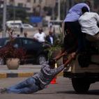 7 agosto 2012 Un hombre trata de subir a un coche de la policía militar tras el funeral por los soldados muertos en un puesto de control en la frontera del Sinaí.