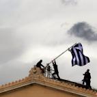 18 abril 2012 Los empleados del parlamento griego colocan una bandera nueva sobre el techo del edificio situado en la plaza Syntagma de Atenas. La anterior había envejecido por el paso del tiempo y por estar a la intemperie. Una metáfora de la...