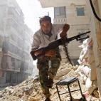 7 agosto 2012 Un combatiente del Ejército de Liberación Sirio busca refugio durante los enfrentamientos con el ejército sirio de Alepo, en el barrio de Saladino.