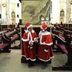 Dos niñas vestidas de Papá Noel conversan antes de la Misa del Gallo una iglesia católica de Pekín, en China, donde hasta los no cristianos tienden cada vez más a celebrar la Navidad.