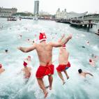 Los papanoeles saltan al agua en la tradicional competición navideña que se celebra en el puerto de Barcelona cada 25 de diciembre desde hace 103 años.