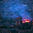 This general view taken from Montparnasse Tower shows flames and smoke as they billow from the roof at Notre-Dame Cathedral in Paris on April 15, 2019. - A fire broke out at the landmark Notre-Dame Cathedral in central Paris, potentially involvi...