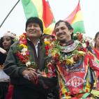 El presidente boliviano Evo Morales, izquierda, estrecha la mano del piloto boliviano Juan Carlos Salvatierra al término de la séptima etapa del Rally Dakar en Uyuni, Bolivia, el domingo 12 de enero de 2014. (AP Foto/Victor R. Caivano)