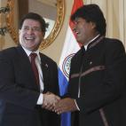 El presidente de Paraguay Horacio Cartes, izquierda, se saluda con el mandatario boliviano Evo Morales durante una reunión en el palacio de gobierno en La Paz, Bolivia, el viernes 6 de diciembre de 2013. (AP Photo/Juan Karita)