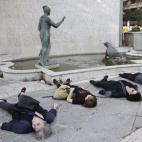 En la plaza de la Cibeles, en el lateral de la fuente, la asociación "Generando Arte" ha colocado flores y ha representado el drama de la violencia machista con varias mujeres tumbadas en el suelo.