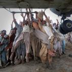 Agosto de 2010. Afectados por las inundaciones en Punjab (Pakist&aacute;n) tratan de escapar agarr&aacute;ndose a un avi&oacute;n de la Armada.