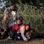 Agosto de 2015. Migrantes sirios cruzan la valla fronteriza entre Hungr&iacute;a y Serbia.