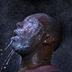 Agosto de 2014. Un hombre se echa leche en la cara despu&eacute;s de ser rociado con gas irritante por las fuerzas de seguridad en Ferguson (Misuri, EEUU), durante unas protestas contra el racismo.