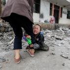 Abril de 2013. Un ni&ntilde;o llora y se agarra a la pierna de su madre frente a su casa de la localidad de Longmen (China), da&ntilde;ada por un terremoto.