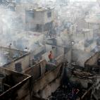 Abril de 2011. Residentes caminan entre las ruinas de la ciudad de Makati (Filipinas), arrasada por el fuego.
