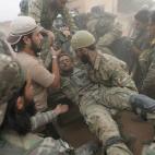 Octubre de 2019. Rebeldes sirios socorren a un compa&ntilde;ero herido en la localidad de Tal Abyad (Siria).
